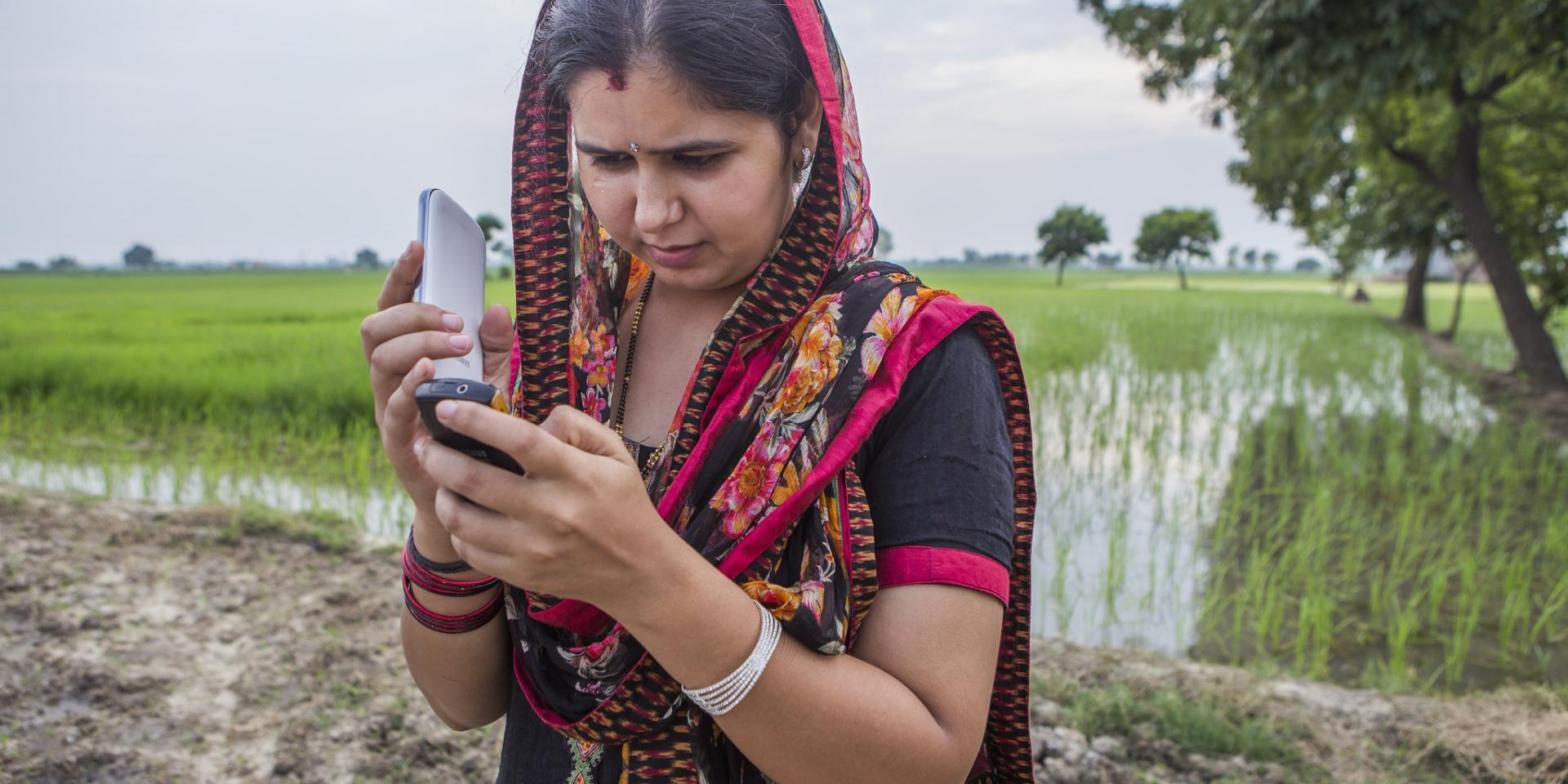 Woman getting weather information via cellphone in India