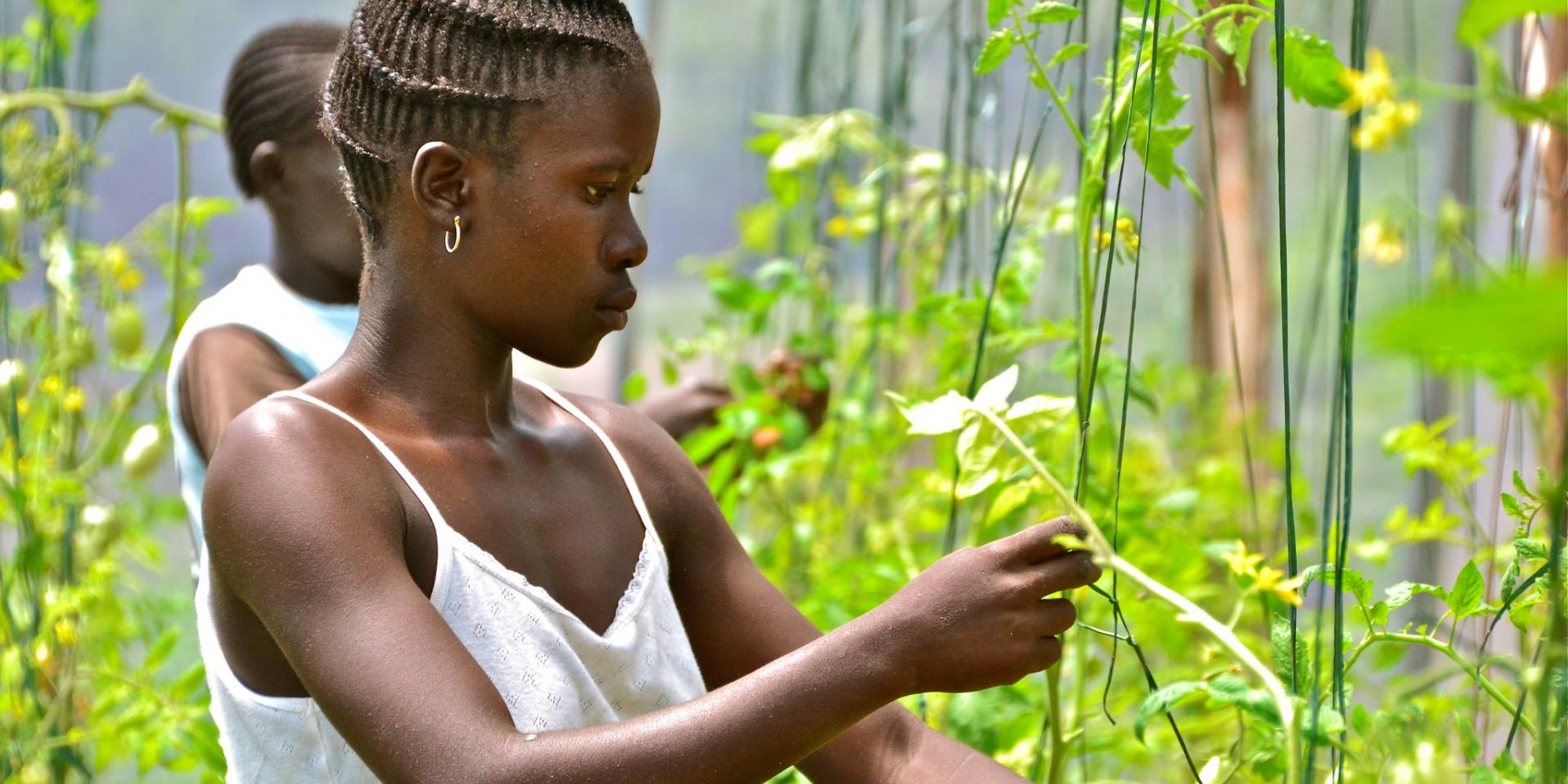 Young women standing next to plants