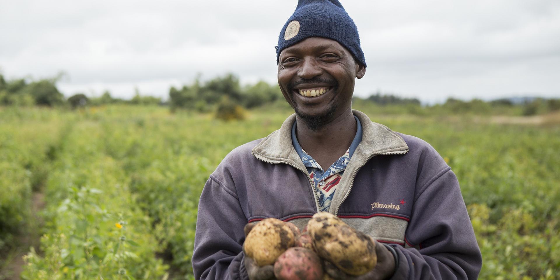 USAID-TAPP-assisted farmer, Huruma Tweve, showing one of three varieties of Irish potatoes he grows in a village close to Iringa, Tanzania.