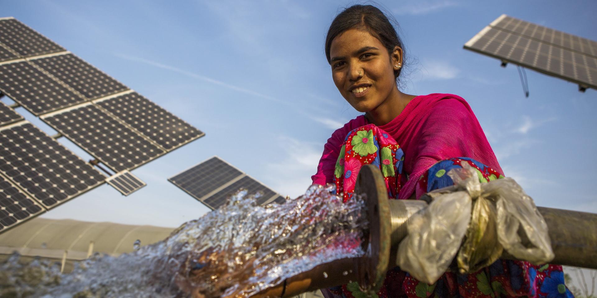 A farm worker uses the water pumped from a solar water pump in a farm.