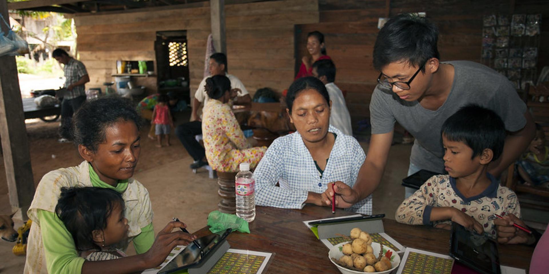 Farmers sitting around a table with digital tablets