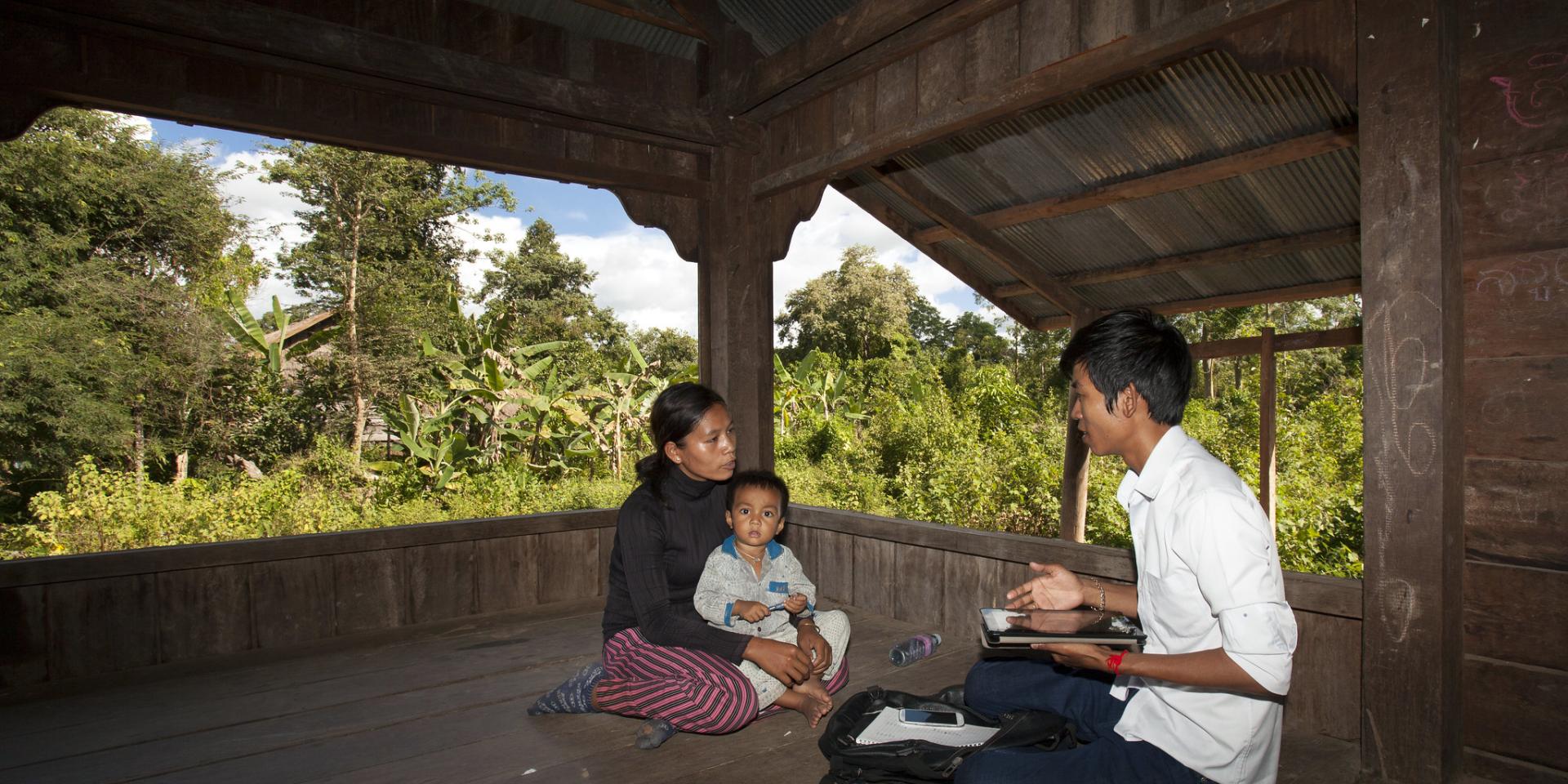 A researcher chatting with a woman farmer and her child