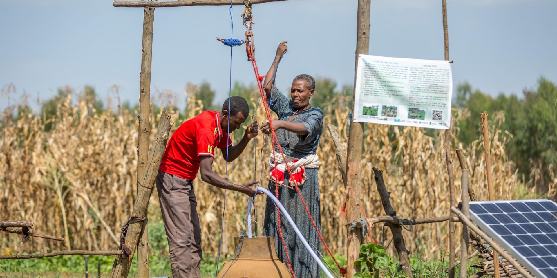In Danghesta village, Dangila district, Amhara region, Ethiopia, woman and man set up a solar-powered pump.