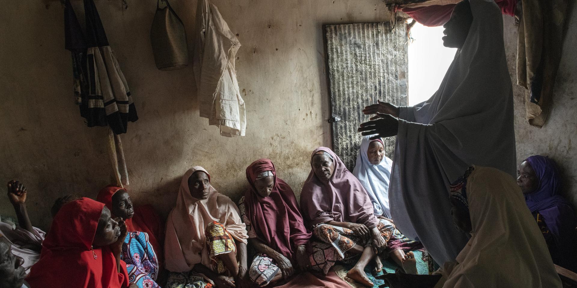 Members of a women's group deposit money into a shared savings box