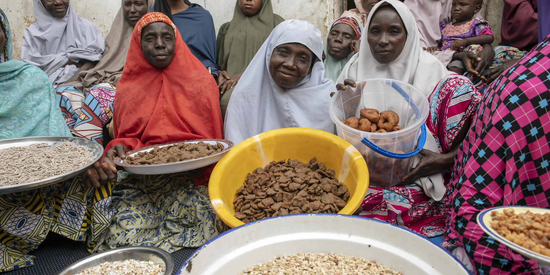 Women holding trays of diverse food