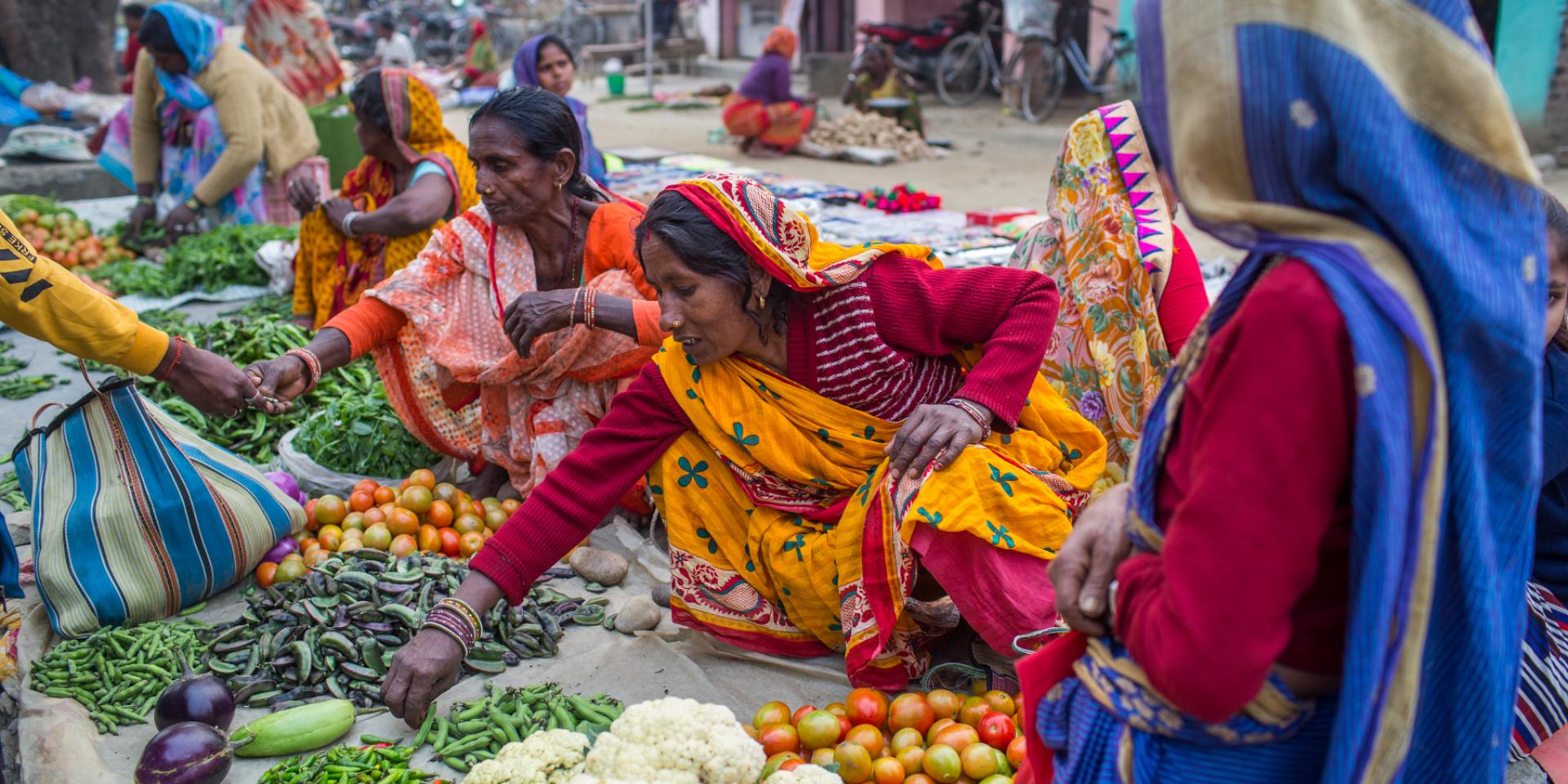 Women in Bangladesh sit on the ground selling their produces