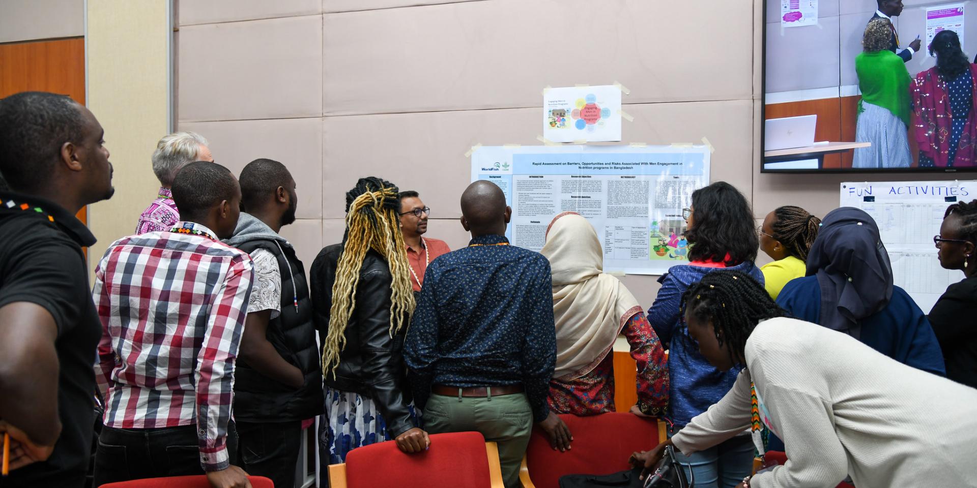 Group of people looking at researcher presenting poster