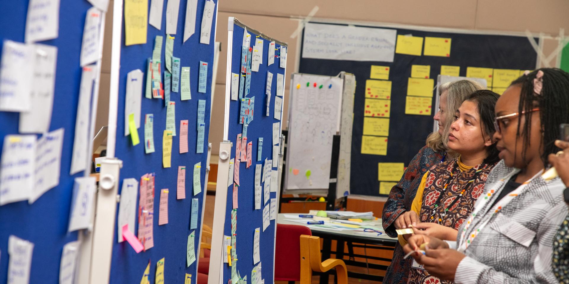 Researchers in a group exercise pinning notes on a board