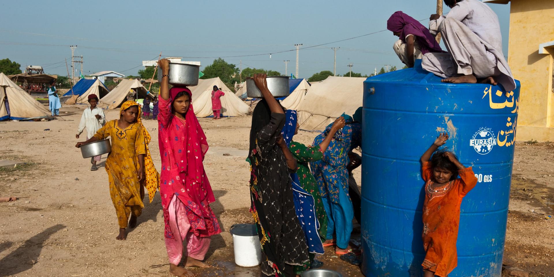 In the outskirts of Thata in Pakistan, women displaced by the 2010 flooding line up to fetch water.