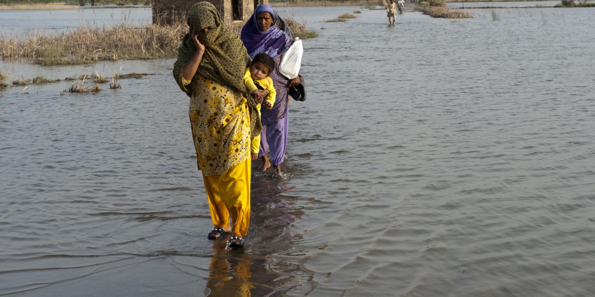 A family crosses the flooded streets of Pakistan.