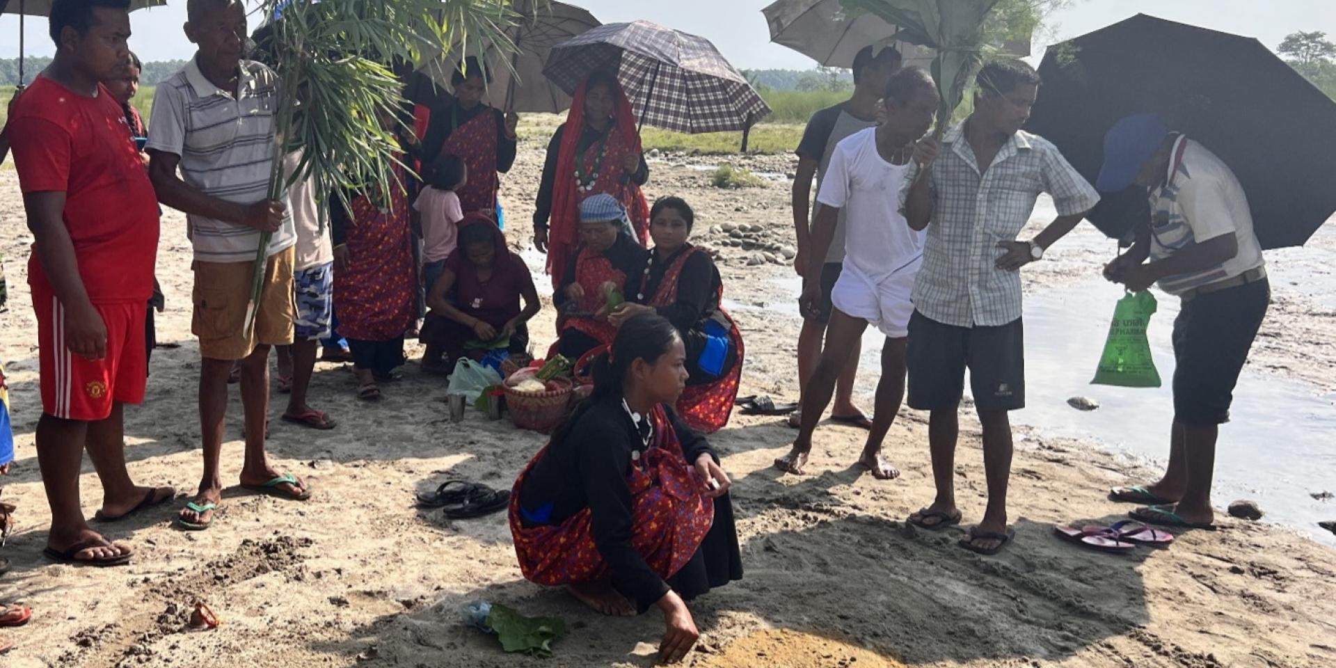 Men and women standing along the shores of a river