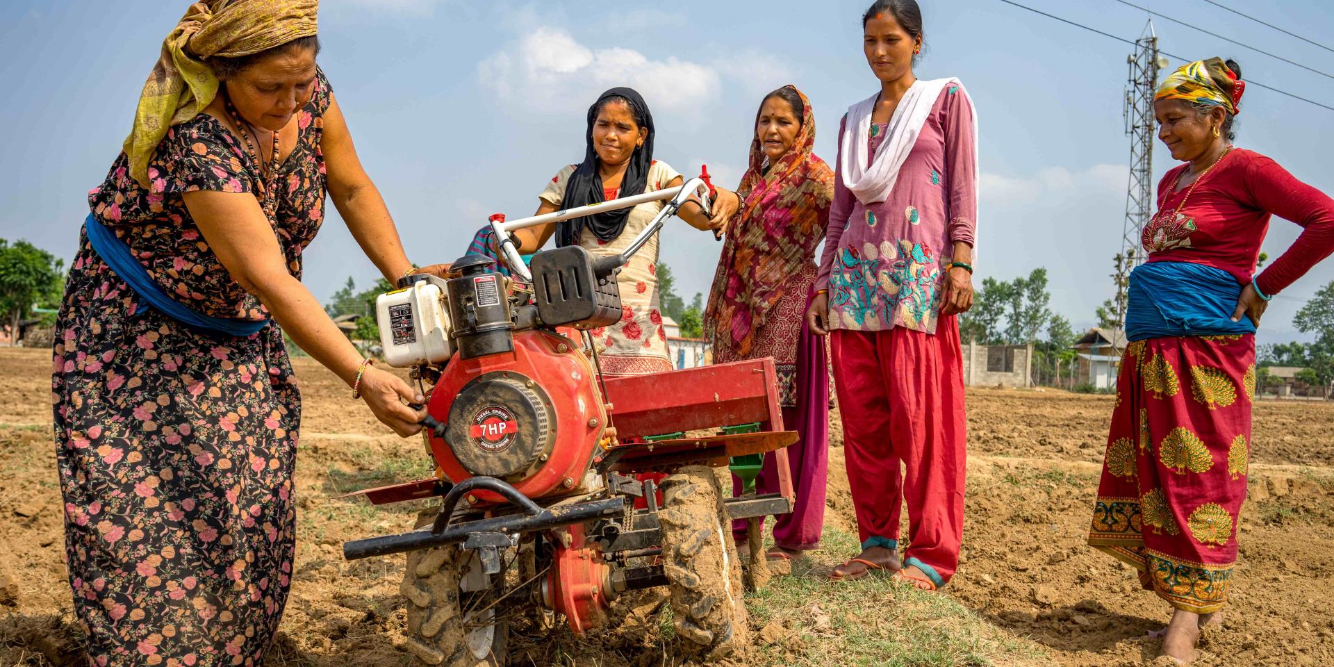 Women farmers use a mini tiller for direct seeding maize during field day in Nepal