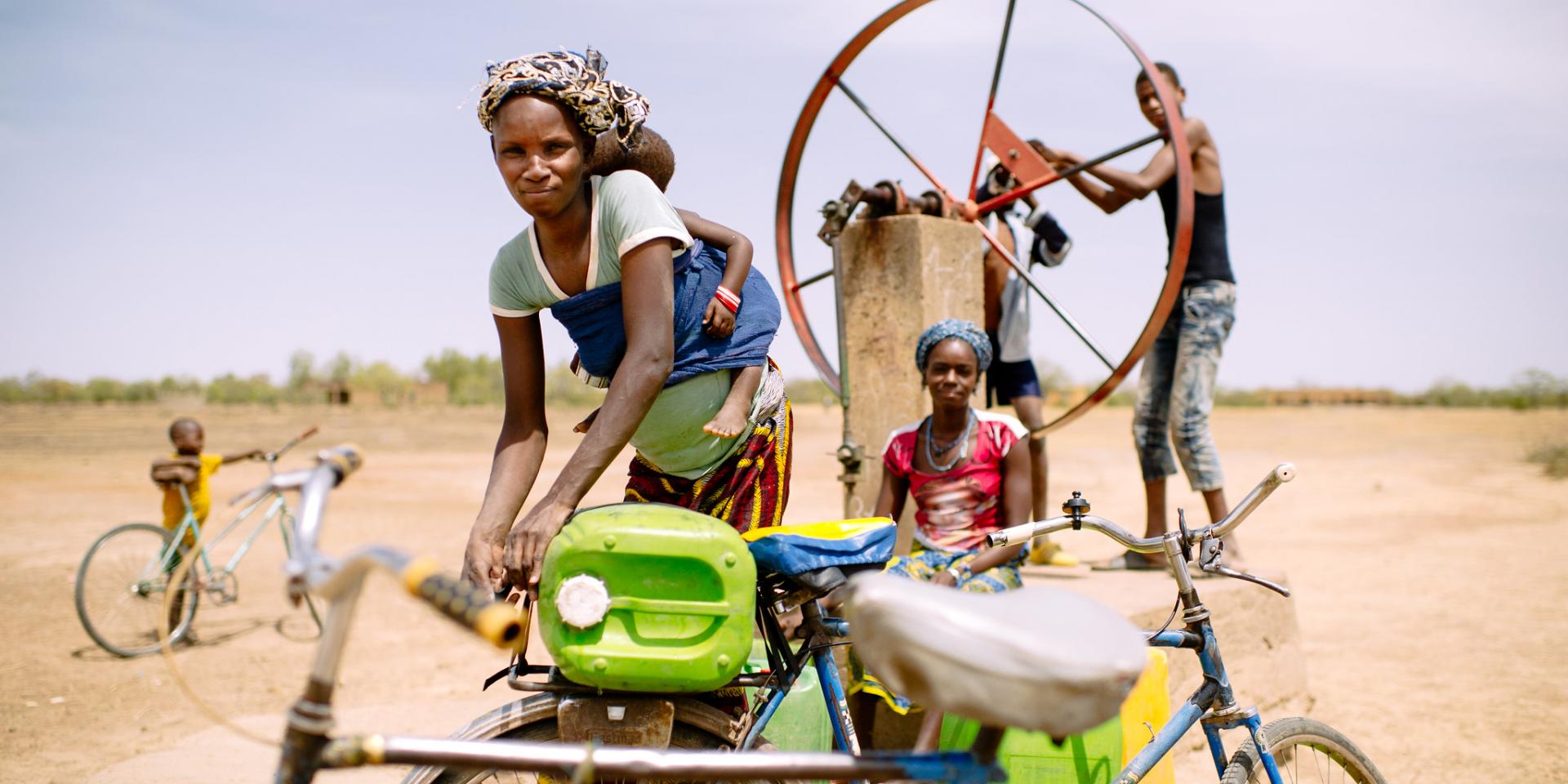 Barry Aliman, 24 years old, bicycles with her baby to fetch water for her family, Sorobouly village near Boromo, Burkina Faso.