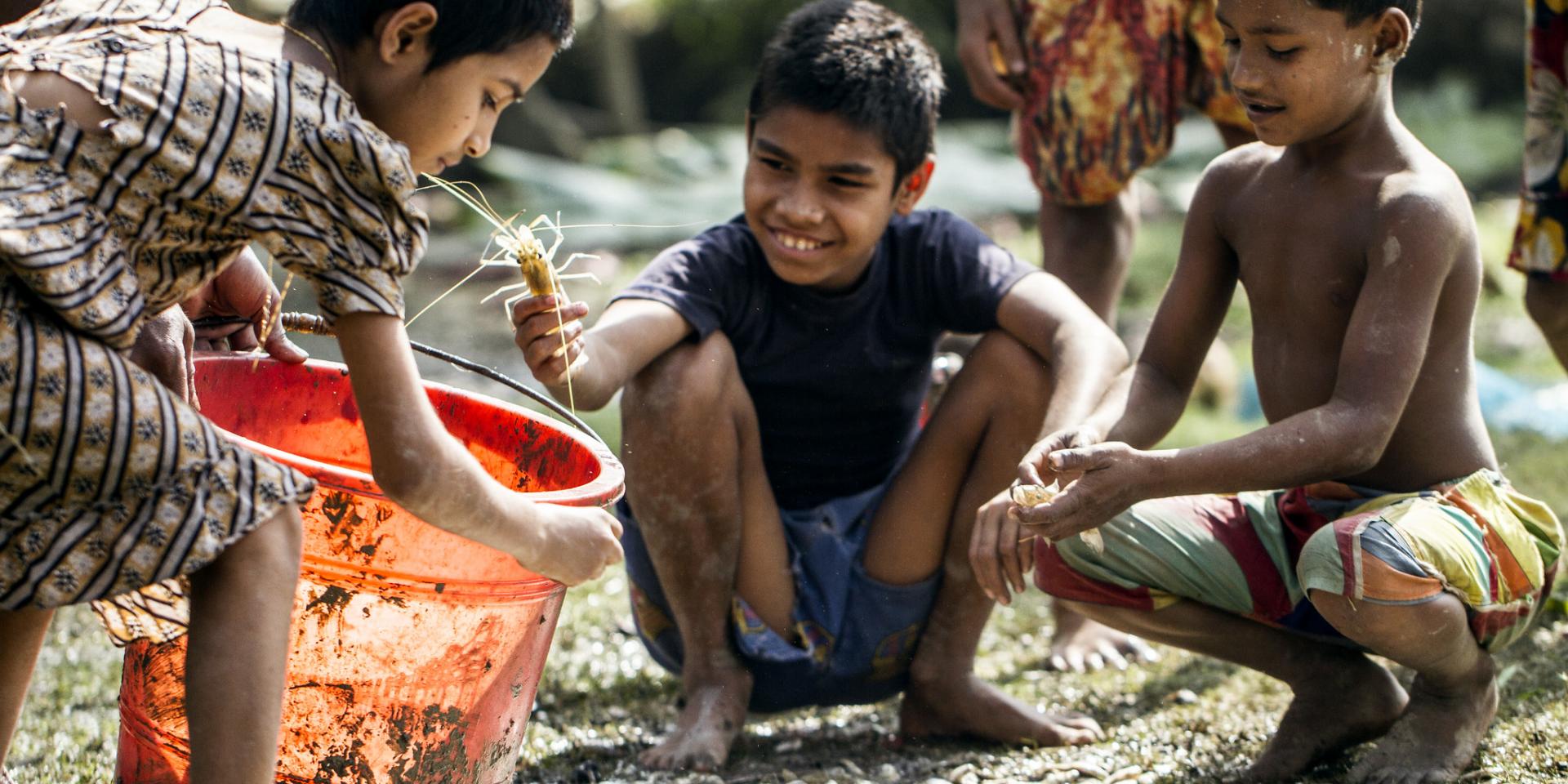 Boys outside with buckets of water.