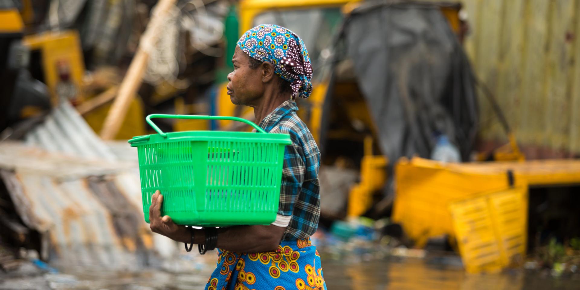 A woman carrying a box through floods