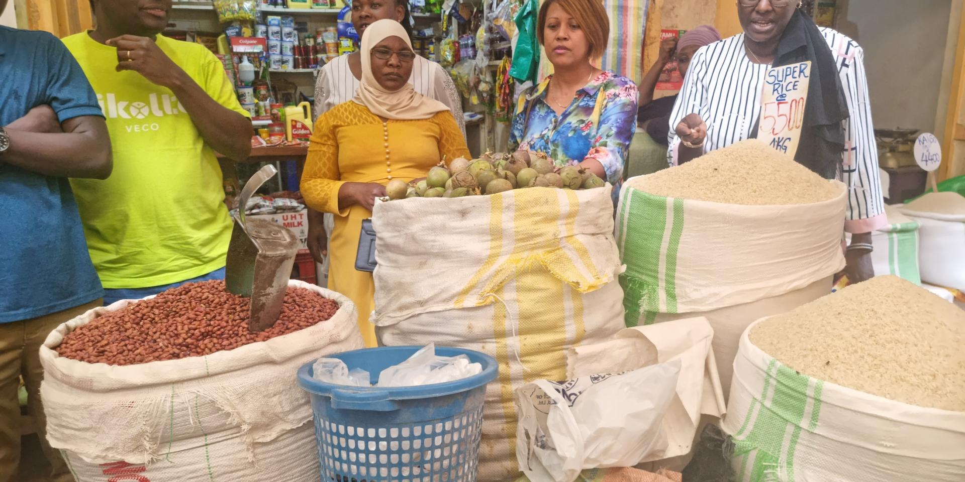 Fauzia Birabwa (in yellow dress) in the market where she retails rice and other commodities
