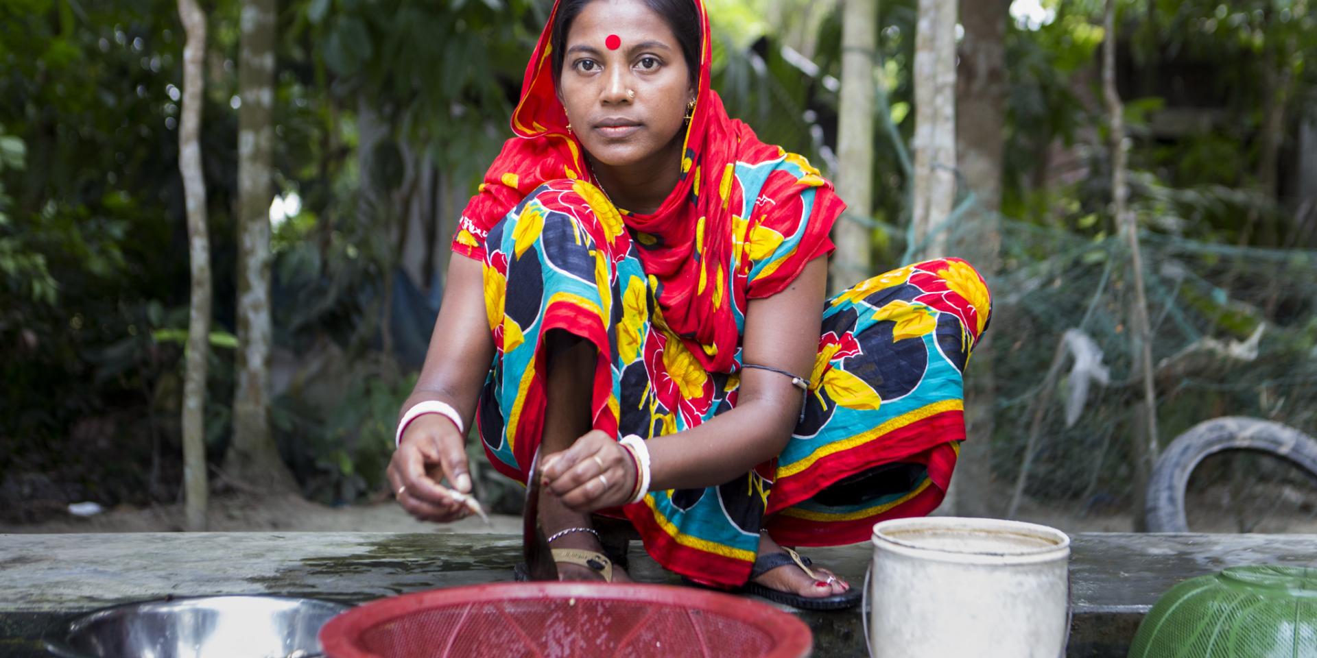 Woman preparing mola in Bangladesh.