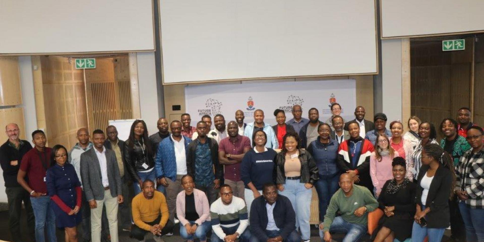 Group of people posing in front of whiteboards in class room