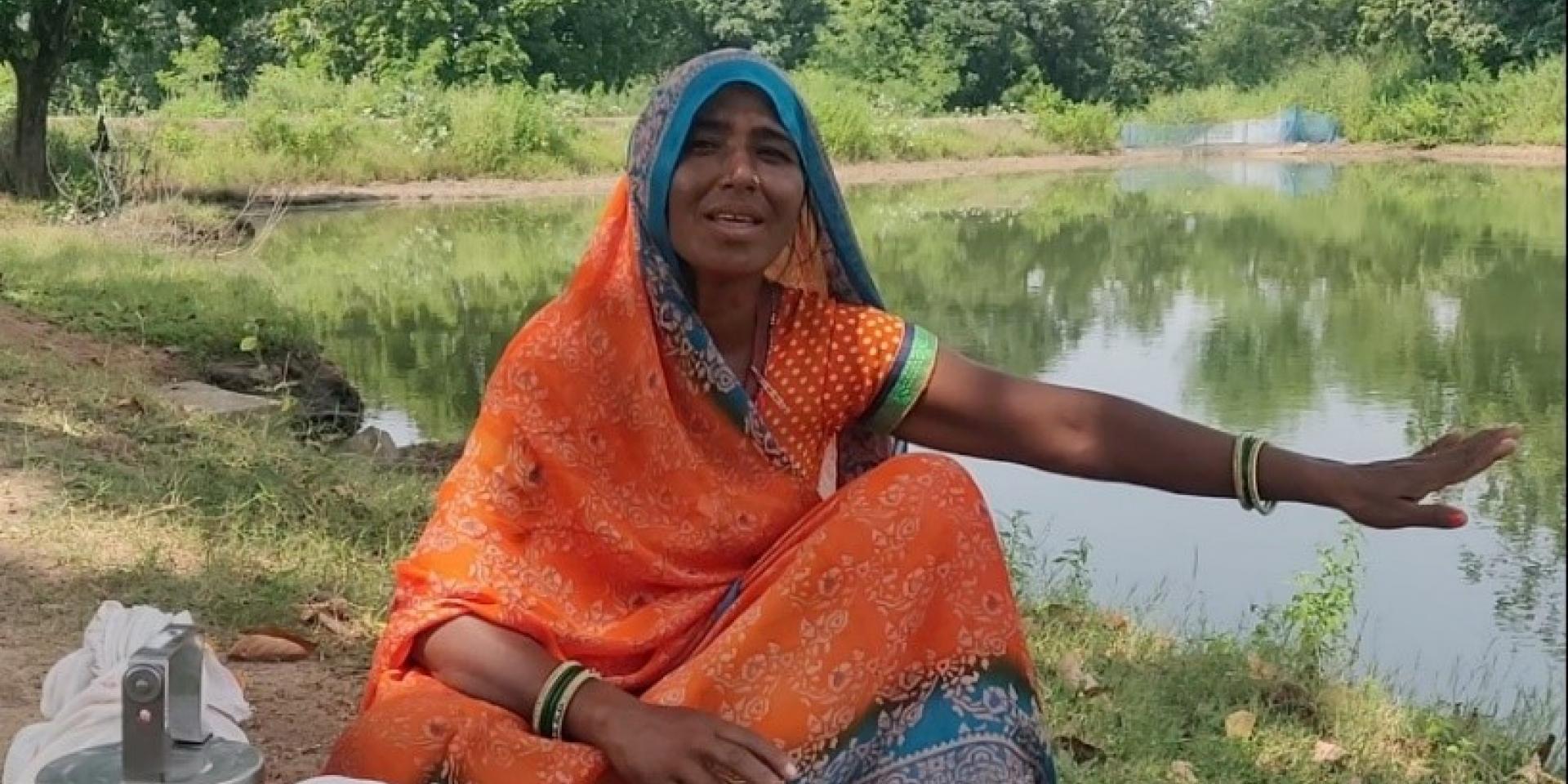 Farmer Dheema Rekbar shows the rainwater harvesting pond that helps her family grow crops.