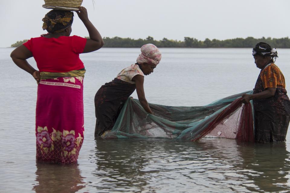 Working as a team; fisher women catching small fish and shrimp in Bagamoyo, Tanzania.