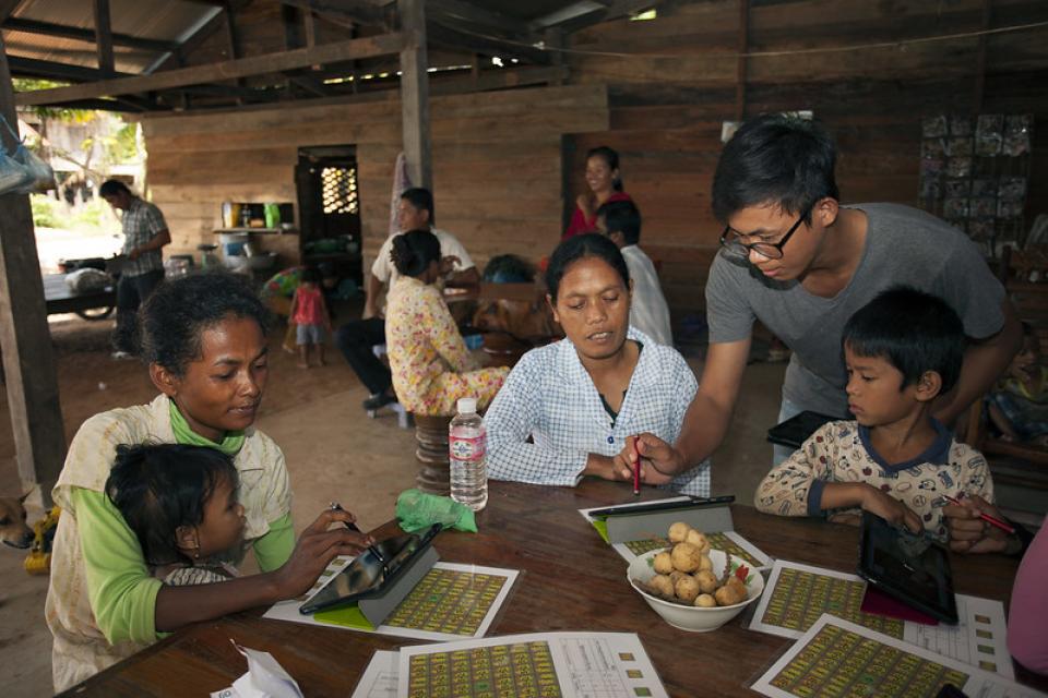 Farmers sitting around a table with digital tablets