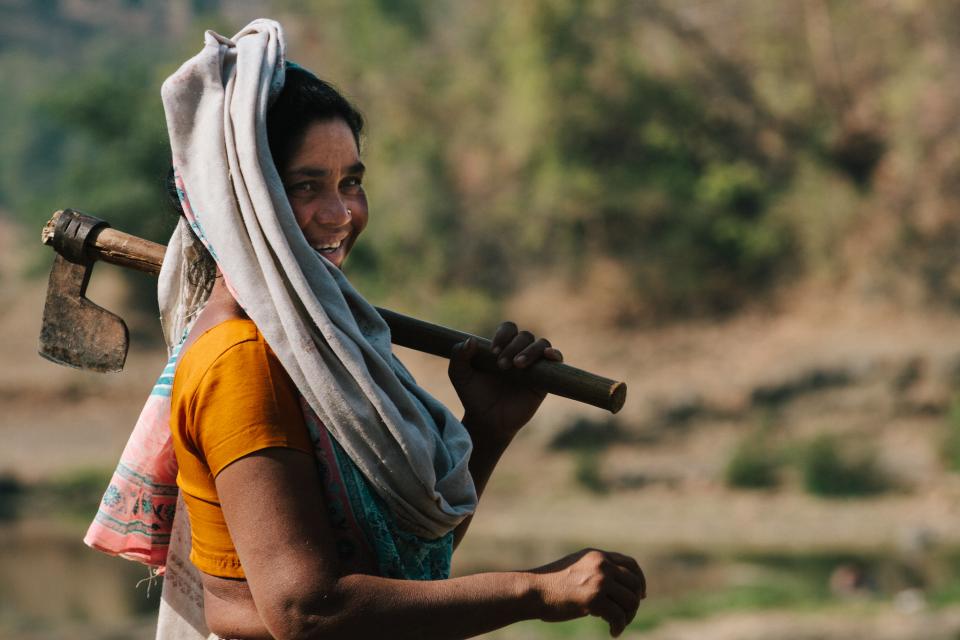 Woman carrying hoe