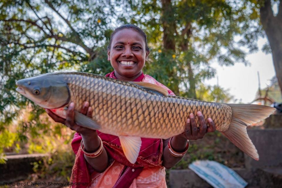 Indian woman smiling holding big fish