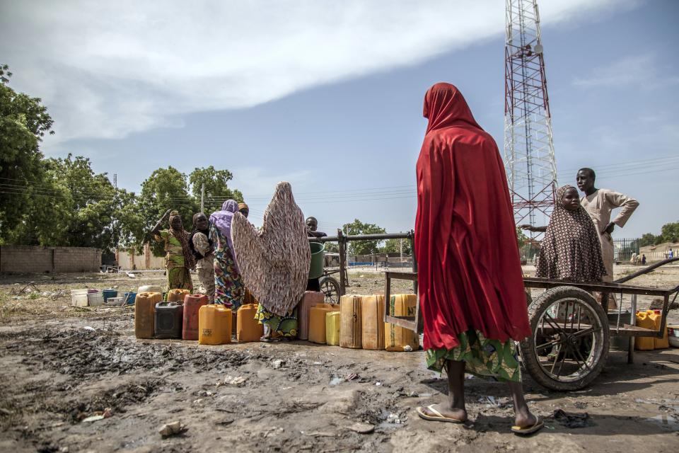 Women and children collect water from a borehole