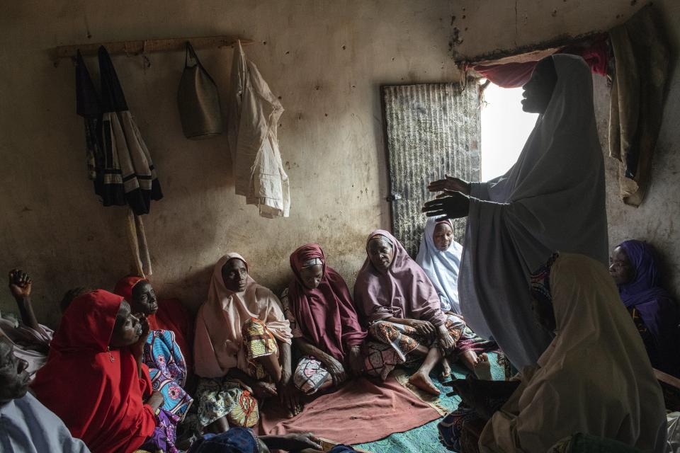 Members of a women's group deposit money into a shared savings box