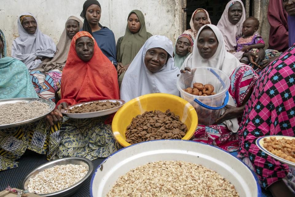 Women holding trays of diverse food