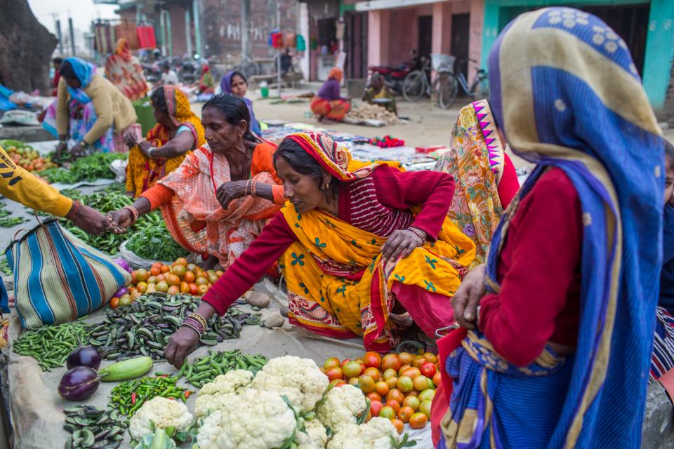 Women in Bangladesh sit on the ground selling their produces
