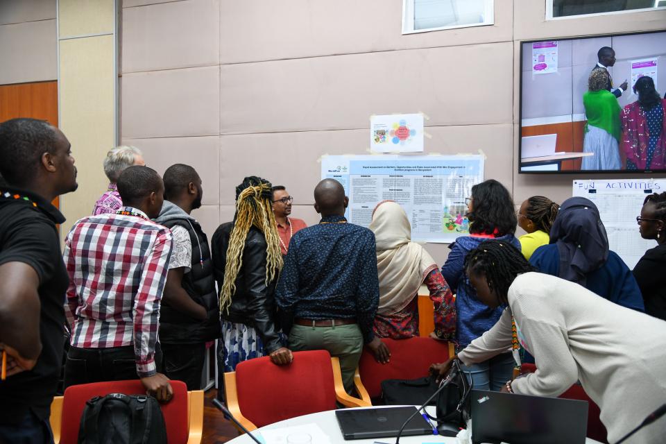 Group of people looking at researcher presenting poster