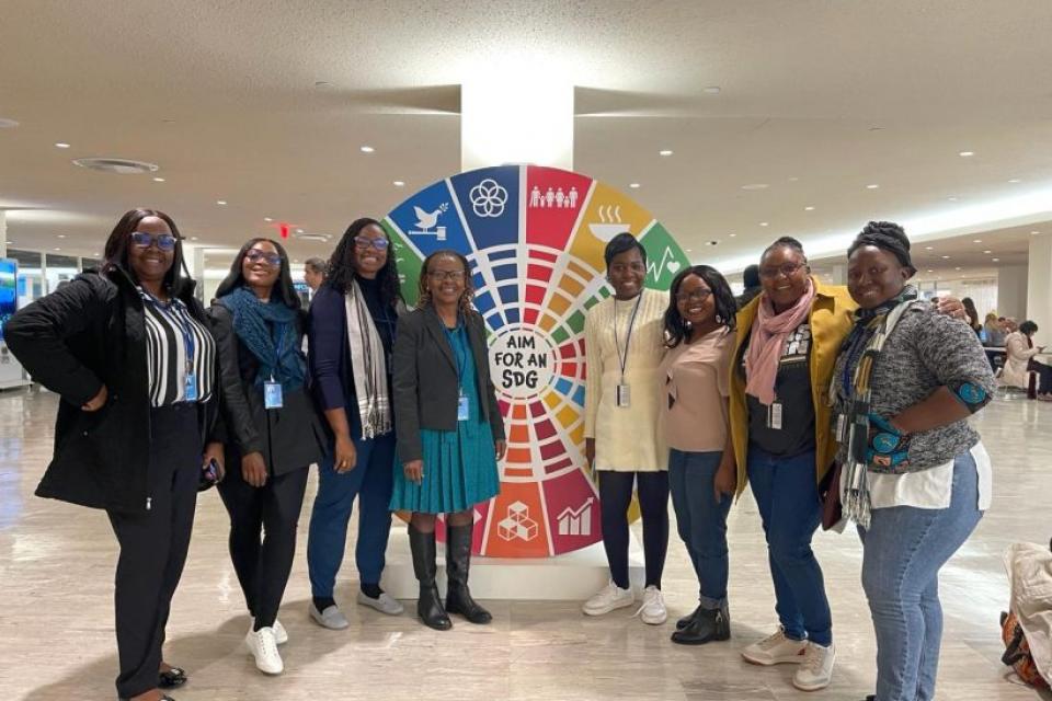 Group of women standing in front of SDG banner