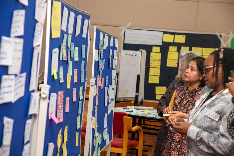 Researchers in a group exercise pinning notes on a board