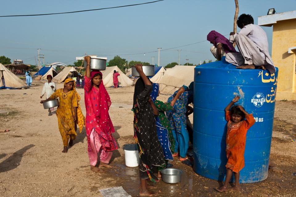 In the outskirts of Thata in Pakistan, women displaced by the 2010 flooding line up to fetch water.