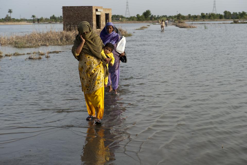 A family crosses the flooded streets of Pakistan.