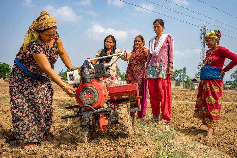 Women farmers use a mini tiller for direct seeding maize during field day in Nepal