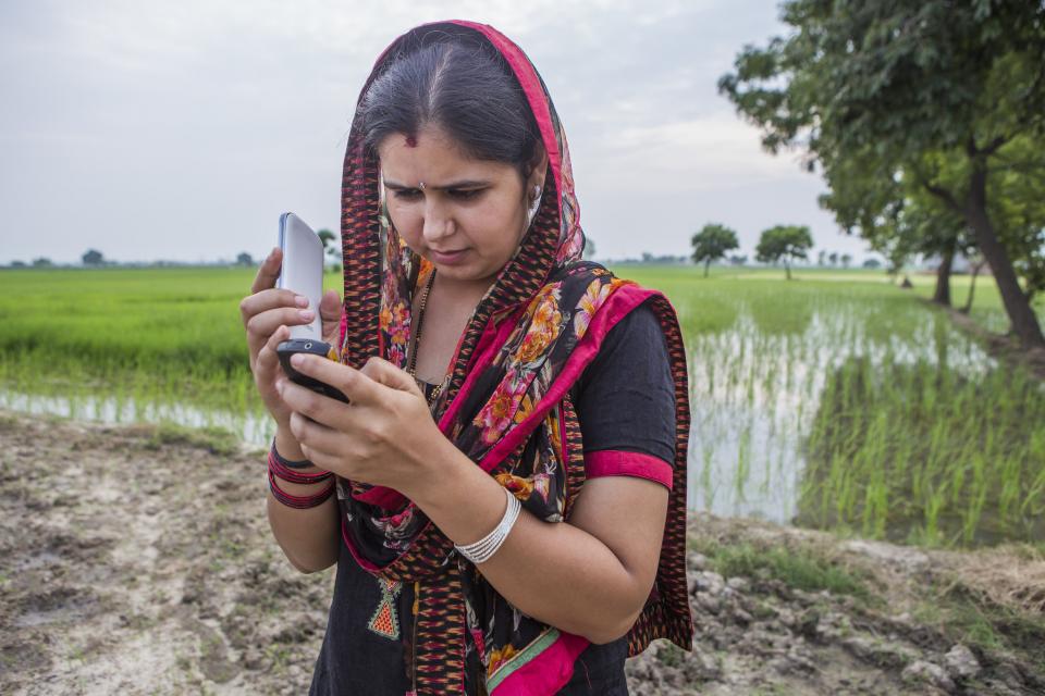 Woman getting weather information via cellphone in India