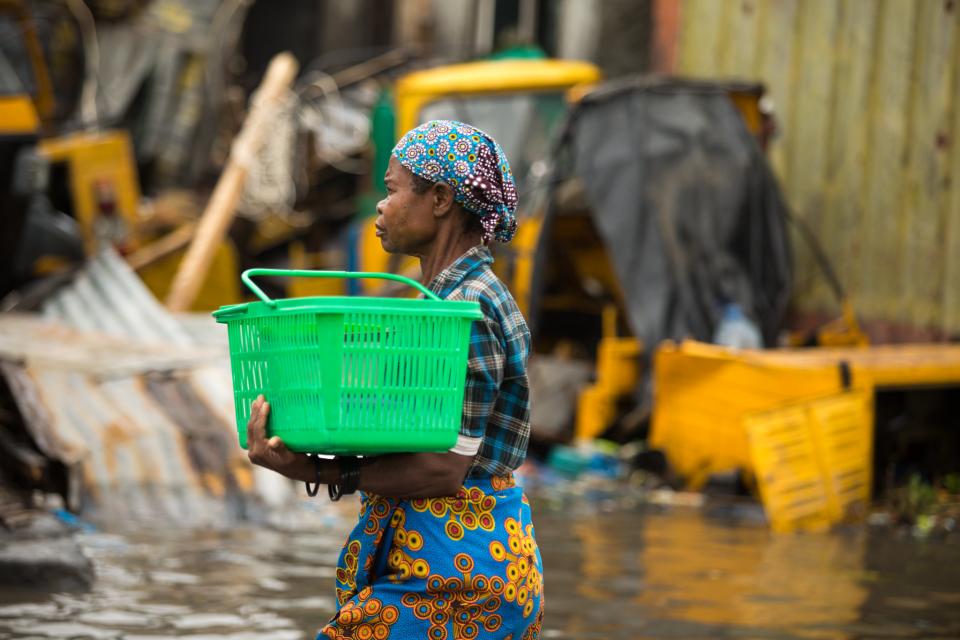A woman carrying a box through floods