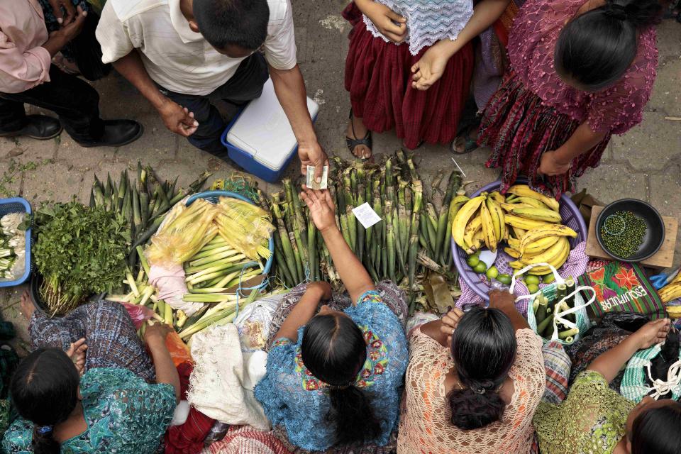 Indigenous women buying and selling produce in Guatemala