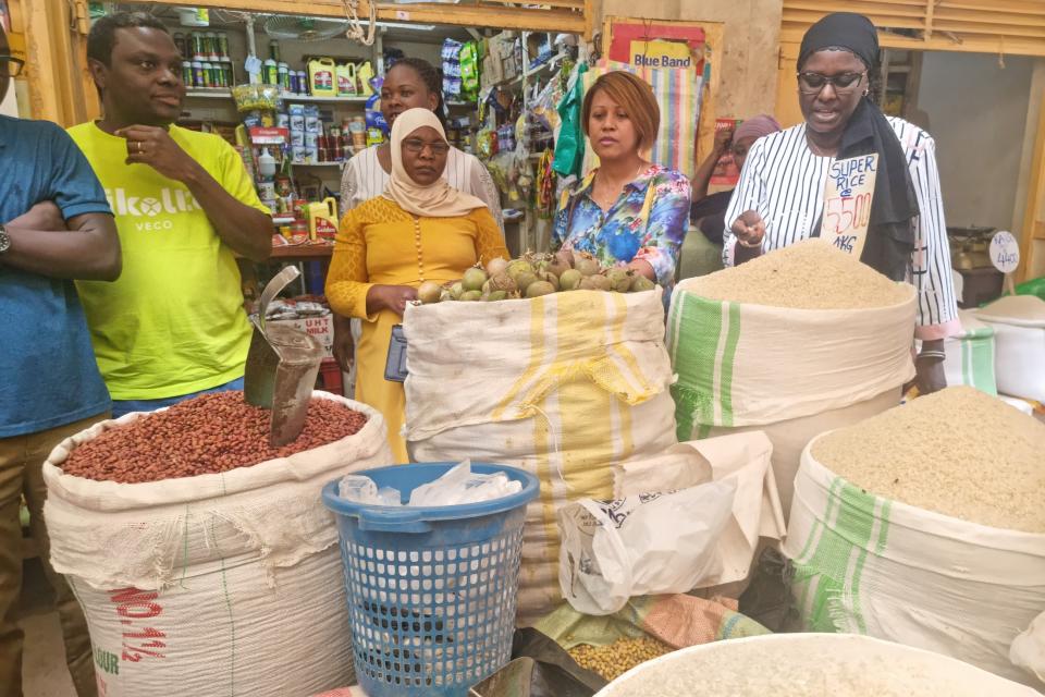 Fauzia Birabwa (in yellow dress) in the market where she retails rice and other commodities