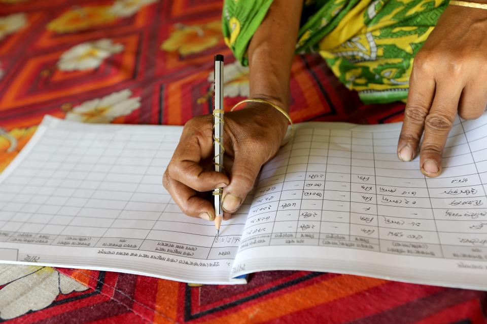 The woman writing data on her data entry book in Jessore, Bangladesh.