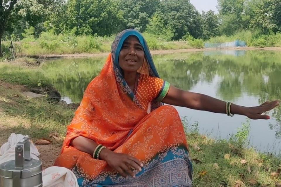 Farmer Dheema Rekbar shows the rainwater harvesting pond that helps her family grow crops.